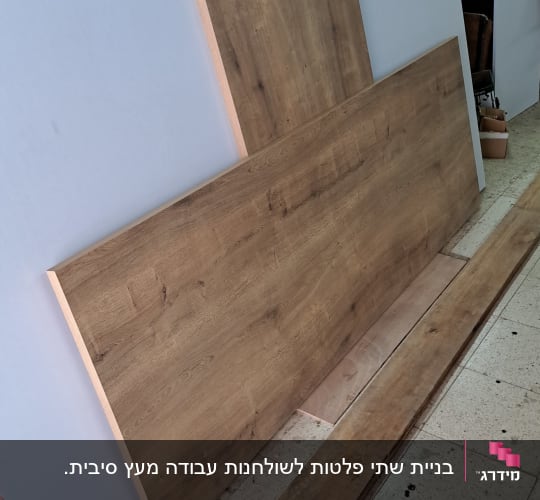 לוחות עץ גדולים בסדנת נגרות עם כלים על הקיר